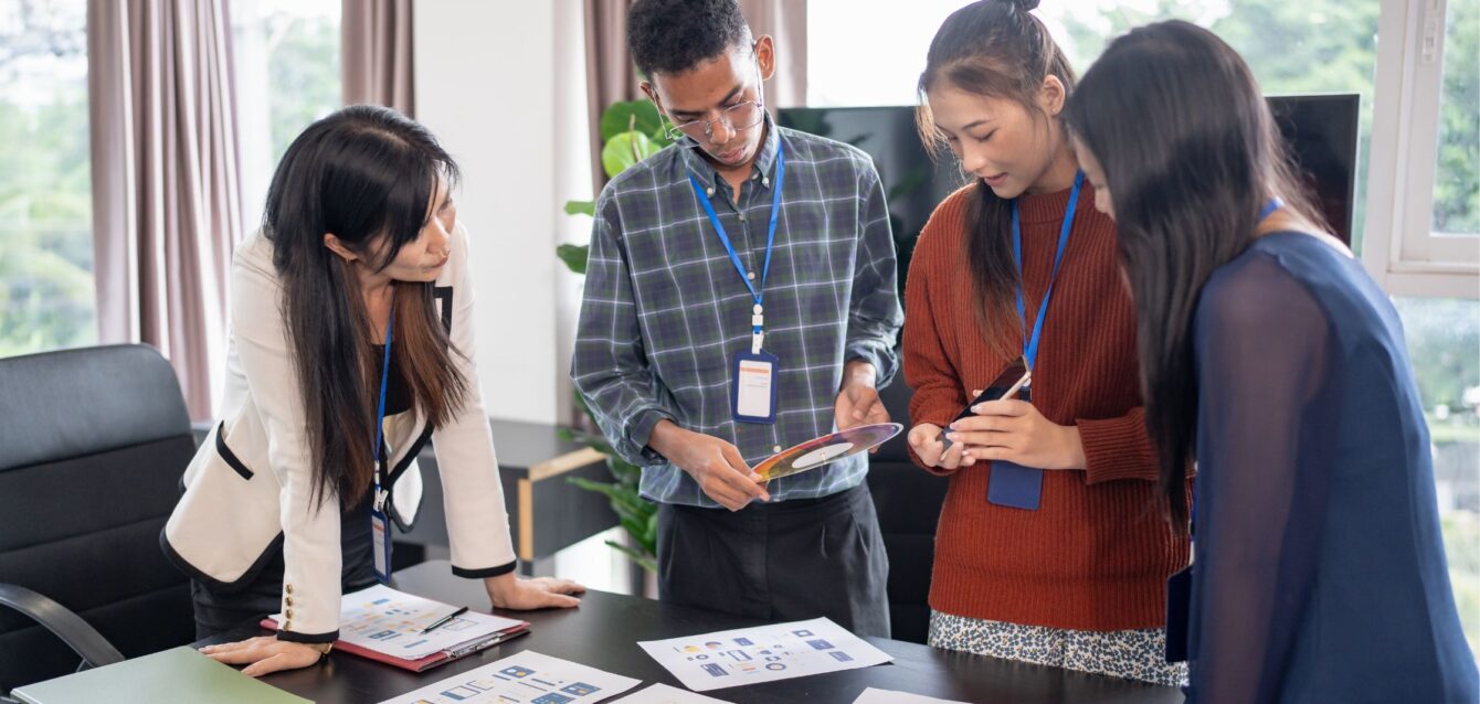 Team of designers discussing creative layouts and color schemes in an office, collaborating on new Graphic Design Programs and visual project ideas.